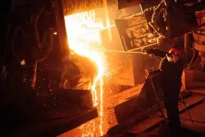 Plant for the production of steel. An electric melting furnace. Factory worker takes a sample for metal