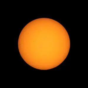 Sun seen with telescope from planet Earth, with sunspots visible as dark spots compared to surrounding regions