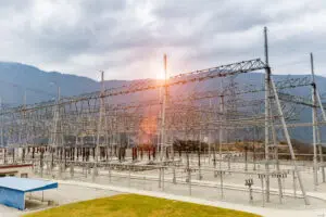 High voltage power transformer substation in valley on a cloudy day
