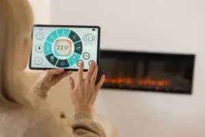 Navigating a smart home tablet app in a cozy living room with fireplace on background. 