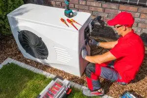An HVAC technician repairing a heat pump unit.