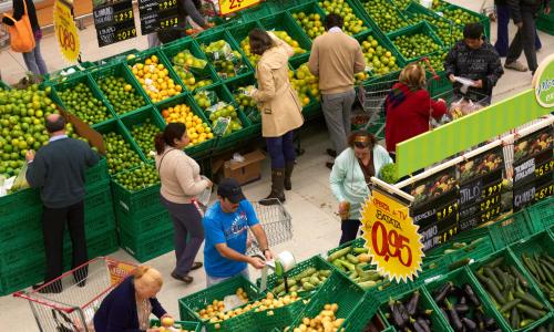 People shop for produce at a market.
