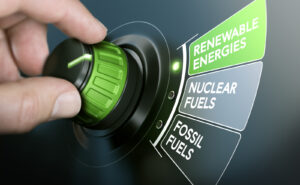 Man turning an energy transition button to switch from fossil fuels to renewable energies.