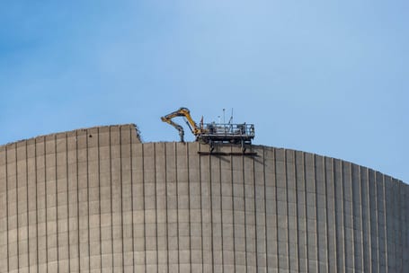 Demolition of the atomic chimney. Remote controlled excavator with shears works from above.